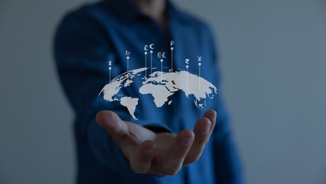 Global currency exchange concept, Hand holding world with virtual line effect and dollar yuan yen euro and pound sterling sign.