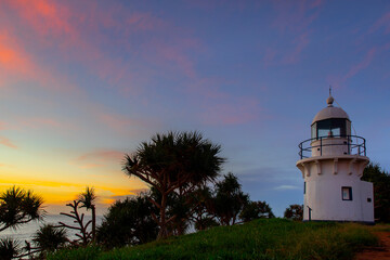 Colourful sunrise sky and pandanus trees at Fingal Head lighthouse, NSW