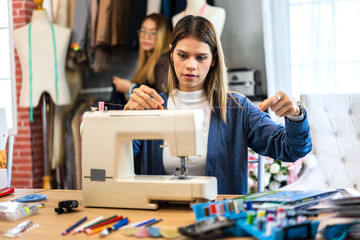 Portrait of young beautiful woman fashion designer stylish sitting and working with color samples.Attractive young girl working with colorful fabrics at fashion studio