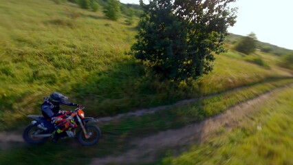 Amazing FPV drone chase as it follows a man riding a motocross bike at high speeds. Concepts of extreme sports, adrenaline, racing.