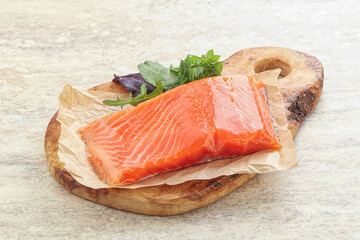 Raw salmon fillet over board