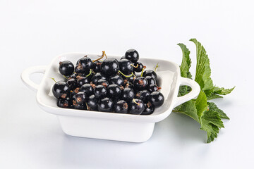 Juicy black currant berries in the bowl