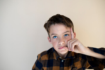 cool pretty young boy with checkered shirt against brown background