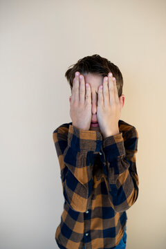 cool pretty young boy with checkered shirt against brown background