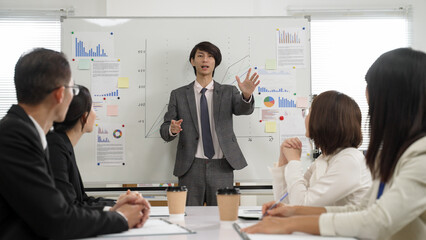Asian group of businesspeople showing approval to male manager’s strategy by applauding during company meeting