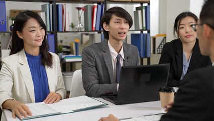 selective focus asian startup male manager of sales team talking with hand gesture while trying to sell services to important customer at meeting