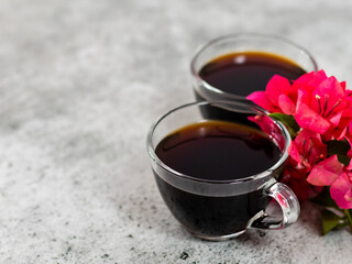 High angle shot of black coffee cups with pink flowers  and copy space on the side.