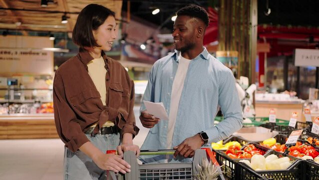Man and woman check availability of goods in shopping cart