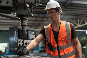industrial Engineer man control lathe machine to drill components in industry manufacturing large...