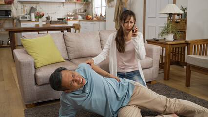 Asian Japanese woman granddaughter rushing into living room to assist fallen grandfather at home....