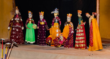 Night photography of a puppet show with various characters wearing traditional dresses.