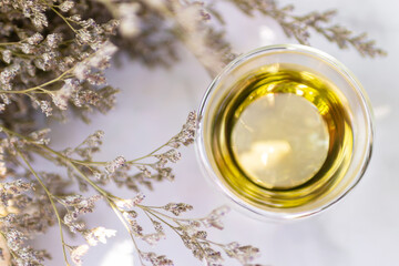 Glass cup of tea with warm sunlight in a garden.