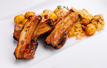 Pickled cabbage with fried pork ribs and spicy potatoes on a plate