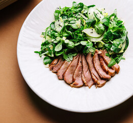 warm salad with a cutting of a duck fillet