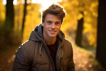 Portrait of a young man walking in a forest during autumn, warm, peaceful