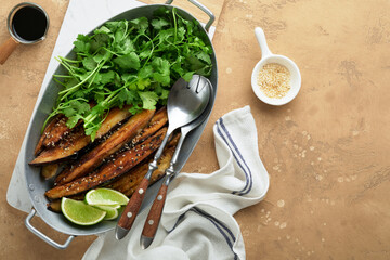 Grilled or baked eggplant slices in rice flour, with cilantro and soy sauce on old beige concrete rustic table background. Top view with copy space.