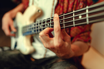Fototapeta na wymiar Close up of male hand playing electric guitar in the dark