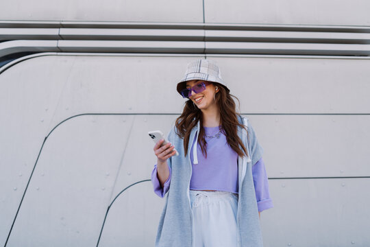 Cute attractive woman using phone in urban city buildings. Portrait, young, woman, cellphone.