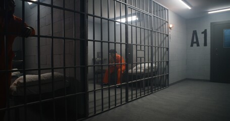 African American inmates in detention center or correctional facility. Depressed man in orange...