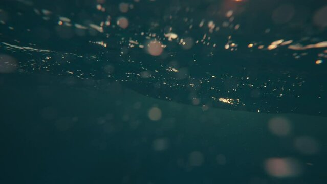 SLOW MOTION, UNDERWATER: Massive turquoise barrel wave breaks over the camera on a sunny summer evening in the scenic Caribbean. Cinematic view of a crystal clear breaking ocean wave at golden sunset.