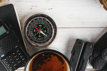 Compass surrounded by mountain gear tools on wooden background