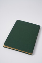 Old dark green notebook from 1950' on a white background.