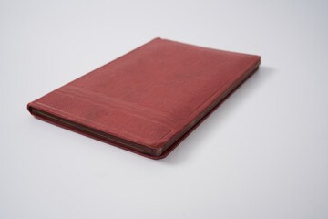 Old red notebook from 1950's on a white background.