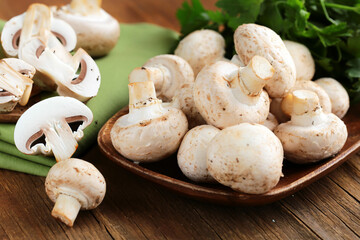 fresh champignon mushrooms on a wooden board
