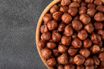 View of a bowl full of hazelnuts on a black background,top view
