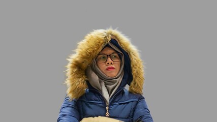 Portrait of young Muslim woman wearing hijab, eyeglasses and blue jacket with faux fur. Tired and unhappy expression. For holiday and winter concept.