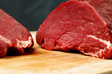 Slice of raw beef fillet on wooden board