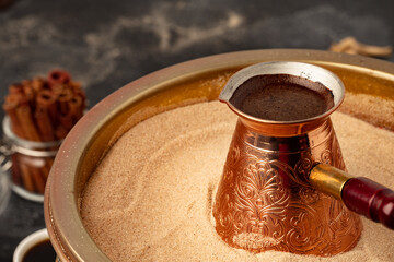 Copper turk with coffee brewing in sand
