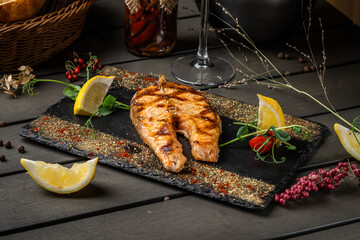 Red salmon fish with Indian spices on a black background.