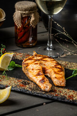 Red salmon fish with Indian spices on a black background.