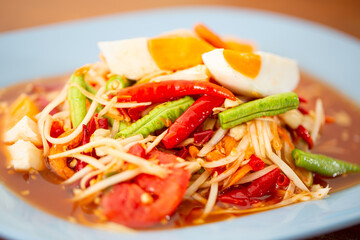 Thai papaya salad cooked with papaya, tomatoes, chili, garlic, green beans, peanuts, dried shrimps and salted egg