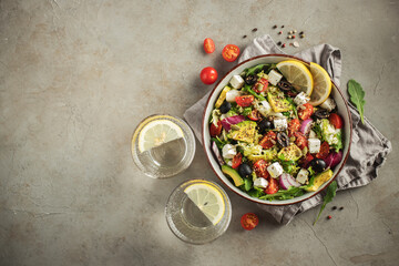 Delicious and healthy green salad of different leaves and vegetables with seeds and olive oil.