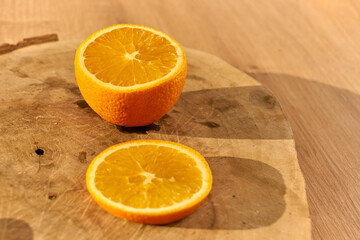 Slices of fresh organic oranges on a wooden kitchen table.