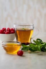 a cup of tea with mint, honey and raspberries.