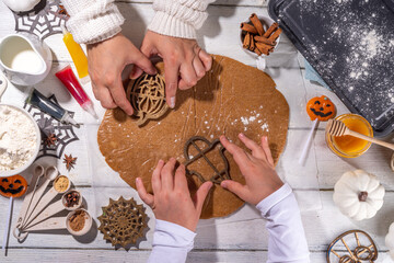 Cooking baking Halloween gingerbread cookies. Preparing for Halloween party holiday, mom and child...