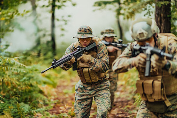 Fototapeta premium A group of modern warfare soldiers is fighting a war in dangerous remote forest areas. A group of soldiers is fighting on the enemy line with modern weapons. The concept of warfare and military