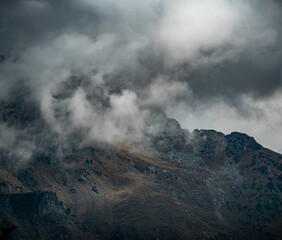 Landscape view of the clouds hanging on the tip of a mountain