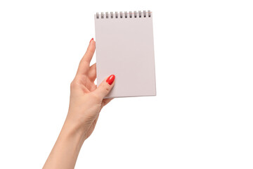 A notebook with empty white paper in woman hands with red nails.