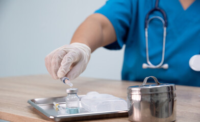 Medicine doctor is filling the medical syringe. Physicain is dawing medicine solution for her patient in emergengy room at the hospital.