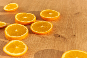Slices of fresh organic oranges on a wooden kitchen table.