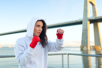 Woman boxing outdoors blue sky background.