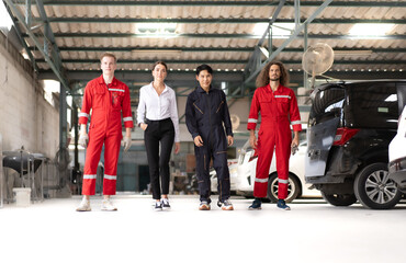 Auto mechanic team walking with smiling woman customer in repair garage ready to fix or maintenance broken engine cars parking in background. Diverse group of people at vehicle repair service shop.