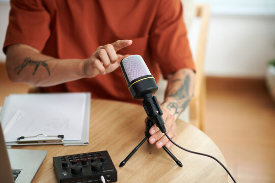 Closeup image of podcaster checking microphone before recording for his blog