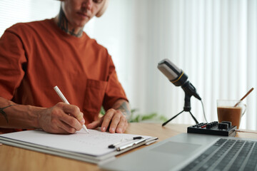 Cropped image of podcaster writing down main ideas before starting to record podcast for blog