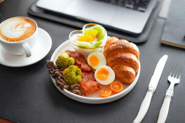 Breakfast croissants with yogurt, boiled eggs and bacon.