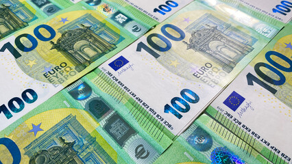 European currency. Stacks of 100 euro bills. Green background of money. Cash banknotes. One hundred euros. The single currency of the European Union.